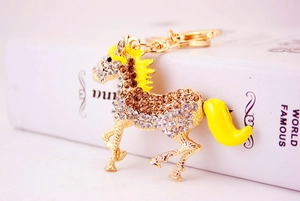 Close-up of golden horse keychain with inlaid white rhinestones and yellow enamel mane