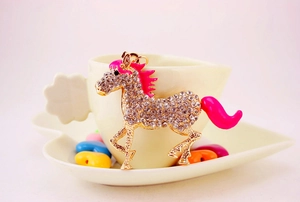 Detail of running horse keychain with sparkling rhinestones and pink enamel finish