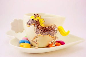 Detail of horse keychain with crystals on a white decorative tray with heart beads