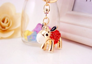 Detailed close-up of golden donkey keychain with sparkling red rhinestones and lobster clasp