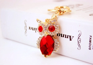 Detailed macro shot of a crystal owl keychain with red gemstones and white rhinestones