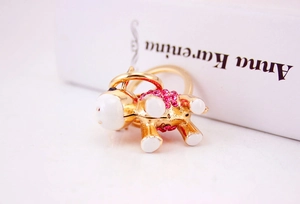 Detailed macro view of a gold-toned donkey keychain with sparkling pink rhinestones and enamel