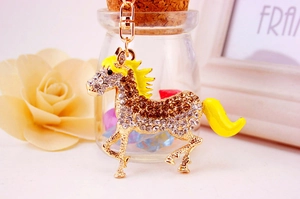 Detail of horse keychain with white rhinestones and yellow enamel accents on gold base