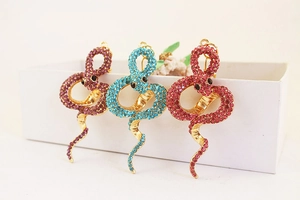 Détail des porte-clés serpent sertis de strass en couleurs violet, bleu et rouge