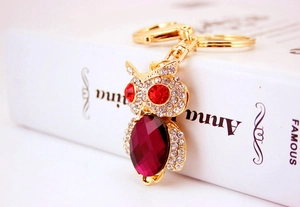 Detailed view of owl keychain featuring sparkling crystals and large purple gemstone