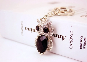 Close-up of sparkling crystal owl keychain with silver finish and black gem accents