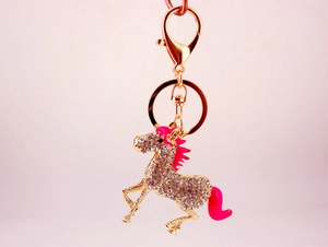 Detailed view of horse keychain with white rhinestones and pink enamel finish