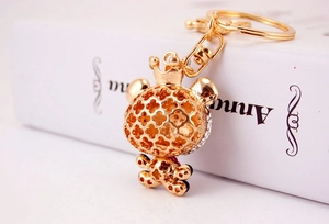 Detail shot of golden crown bear keychain with rhinestone inlay and clover hollow head