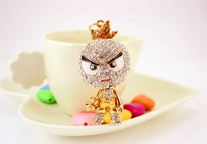 Détail d'un porte-clés personnage cartoon avec strass brillants et couronne dorée