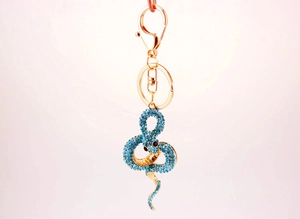 Détail du porte-clés serpent doré avec strass bleu ciel et fermoir mousqueton