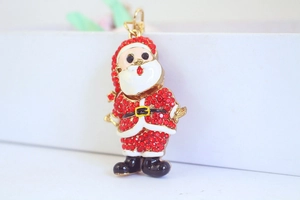 Détail du porte-clés Père Noël avec strass rouges et émail blanc sur métal doré