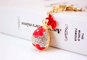 Détail d'un porte-clés sac à monnaie en cristal étincelant avec fleurs rouges