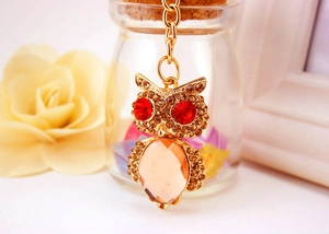 Close-up of golden owl keychain with sparkling brown rhinestones and champagne crystal