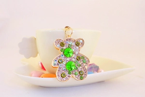Dettaglio portachiavi orsetto di cristallo con strass verdi appeso a tazza bianca