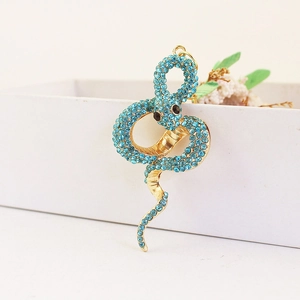 Porte-clés serpent doré serti de cristaux bleu ciel suspendu à une boîte blanche