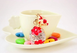 Gros plan du porte-clés sac à monnaie en strass et fleurs sur une tasse en céramique
