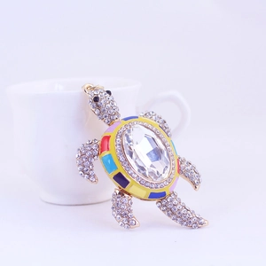 Porte-clés tortue dorée avec strass colorés et un grand cristal transparent facetté