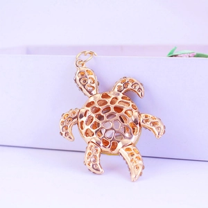 Porte-clés tortue dorée avec motif alvéolé évidé et décorations en strass brillants