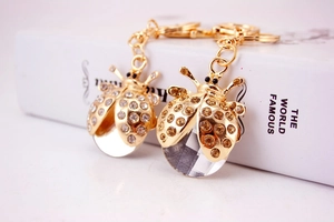 Détail d'un porte-clés coccinelle doré de luxe avec strass brillants et pendentif cristal