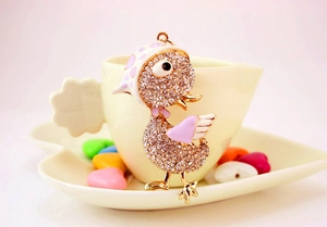 Détail du porte-clés canard avec cristaux et émail sur une tasse en porcelaine