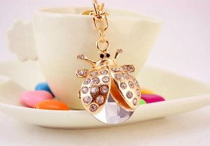 Vue détaillée du porte-clés coccinelle avec cœur en cristal sur une tasse