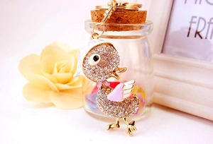 Détail d'un joli porte-clés canard serti de strass avec alliage doré et émail rose brillant