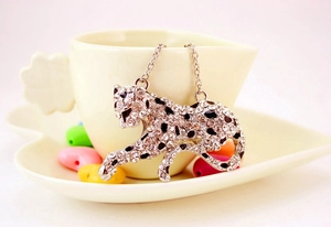 Detail of silver leopard keychain with white and black crystals on a decorative tray