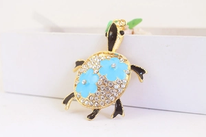 Détail du porte-clés tortue avec cristaux brillants et motif de fleurs bleues