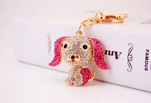Dettaglio di un portachiavi a forma di carlino con strass rosa e bianchi e base dorata