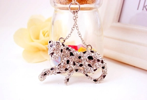 Detailed close-up of a sparkling leopard charm keychain with white rhinestones and black spots