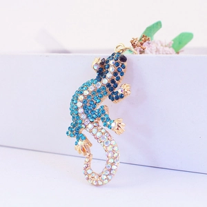 Porte-clés gecko scintillant avec cristaux bleus sur une base en métal doré