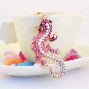 Porte-clés lézard étincelant avec strass roses et violets sur une tasse de café