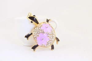 Gros plan du porte-clés tortue avec strass étincelants et fleurs roses décoratives