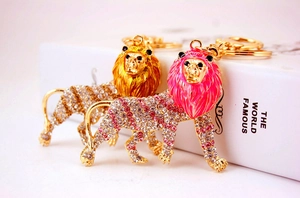 Detail of lion pendants featuring gold plating and shimmering pink and white rhinestones
