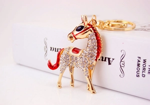 Detail of horse keychain with gold alloy plating, clear rhinestones and red enamel finish