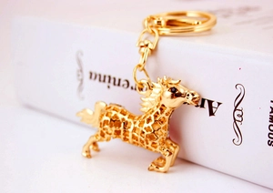 Macro detail of golden horse keychain featuring clover hollow pattern and crystal eye