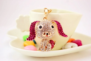 Dettaglio del portachiavi carlino con strass appeso al bordo di una tazza a cuore