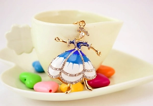Dettaglio di un ciondolo ballerina con smalto blu e strass scintillanti su montatura oro