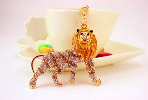 Detailed view of lion keychain with sparkling rhinestones next to a white teacup