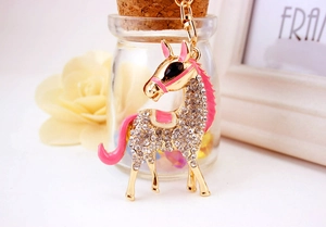 Detail of a sparkling horse keychain featuring pink enamel accents and white rhinestones