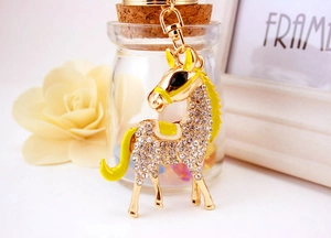 Detail showing gold horse keychain with white rhinestones and yellow enamel accents