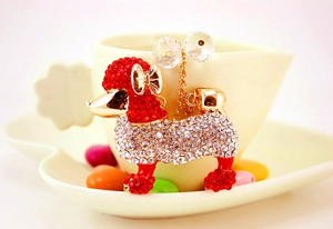 Détail d'un pendentif caniche serti de cristaux avec nœud doré et strass de luxe