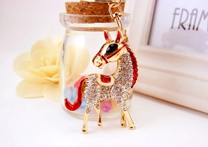 Detailed view of horse keychain with white rhinestones and red enamel details