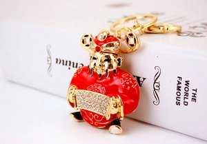 Close-up of God of Wealth keychain with red enamel, gold plating, and sparkling rhinestones