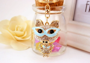 Détail d'un porte-clés cochon mignon avec strass brillants et lunettes bleues