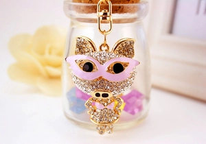 Détail d'un porte-clés cochon en strass avec masque rose et bikini sur placage d'or