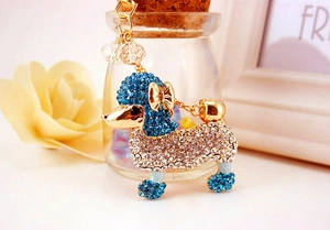 Vue macro du porte-clés caniche avec strass bleus et transparents sur alliage doré
