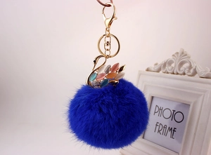 Dettaglio del portachiavi con pompon blu reale e ciondolo a forma di cigno