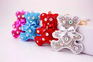 Detailed macro view of four sparkling crystal bear keychains in vibrant colors