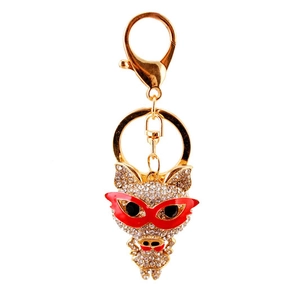 Porte-clés cochon doré avec strass brillants et lunettes rouges sur fond blanc pur